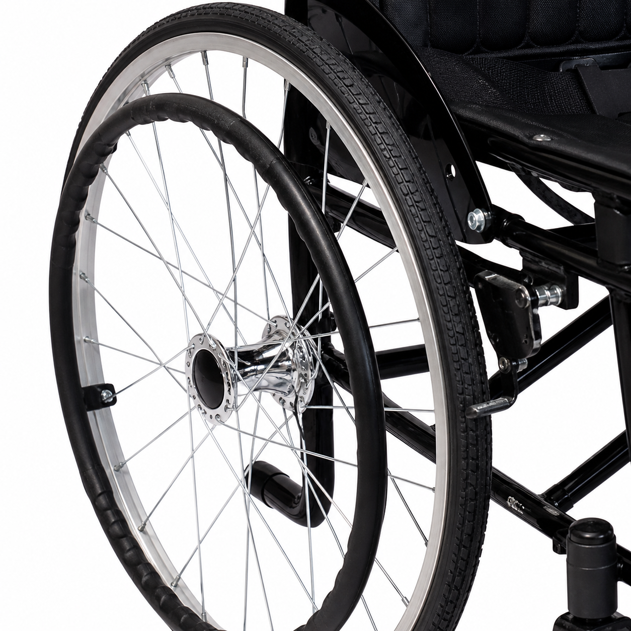Detalle de llanta trasera de silla de ruedas manual negra con rin metálico y radios de acero